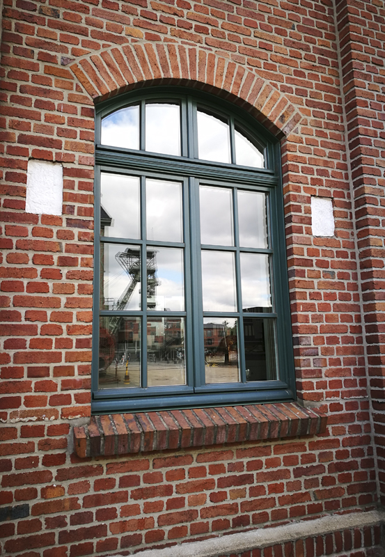 Das Foto zeigt die beiden Fördergerüste der Zeche Zollern Dortmund. Hier im Spiegelbild eines Fensters.