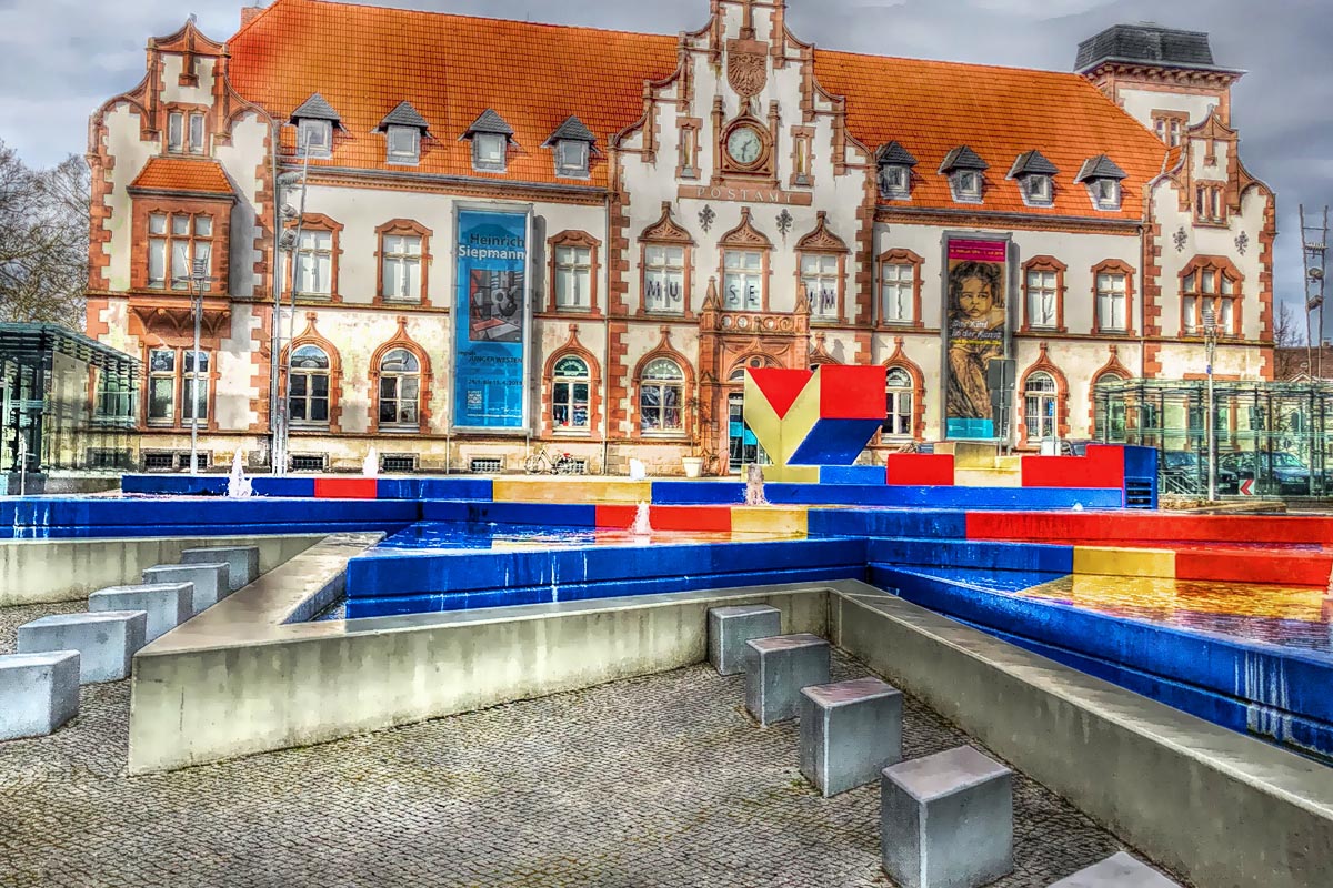 Das Foto zeigt das Kunstmuseum Alte Post mit dem Hajek-Brunnen