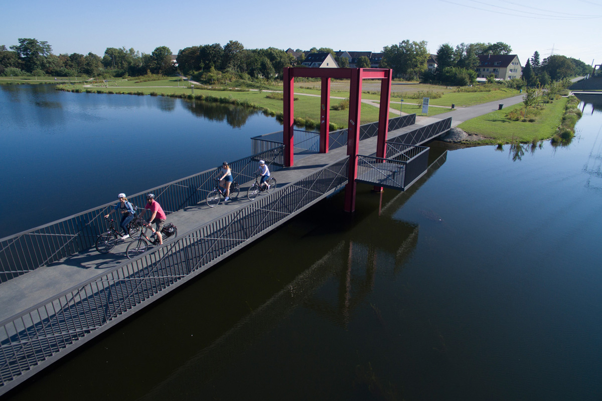 Das Foto zeigt Radler auf einer Brücke auf der Niederfeldsee in Essen