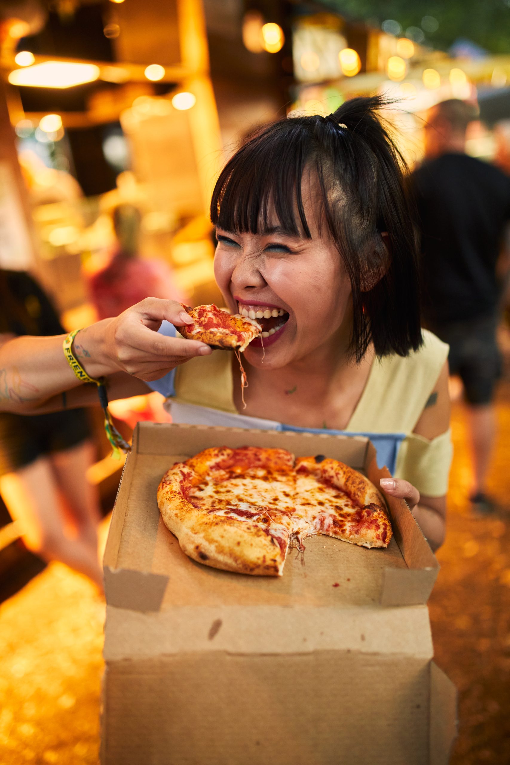 Das Foto zeigt eine Besucherin mit Pizza beim Ruhr Reggae Summer in Mülheim an der Ruhr