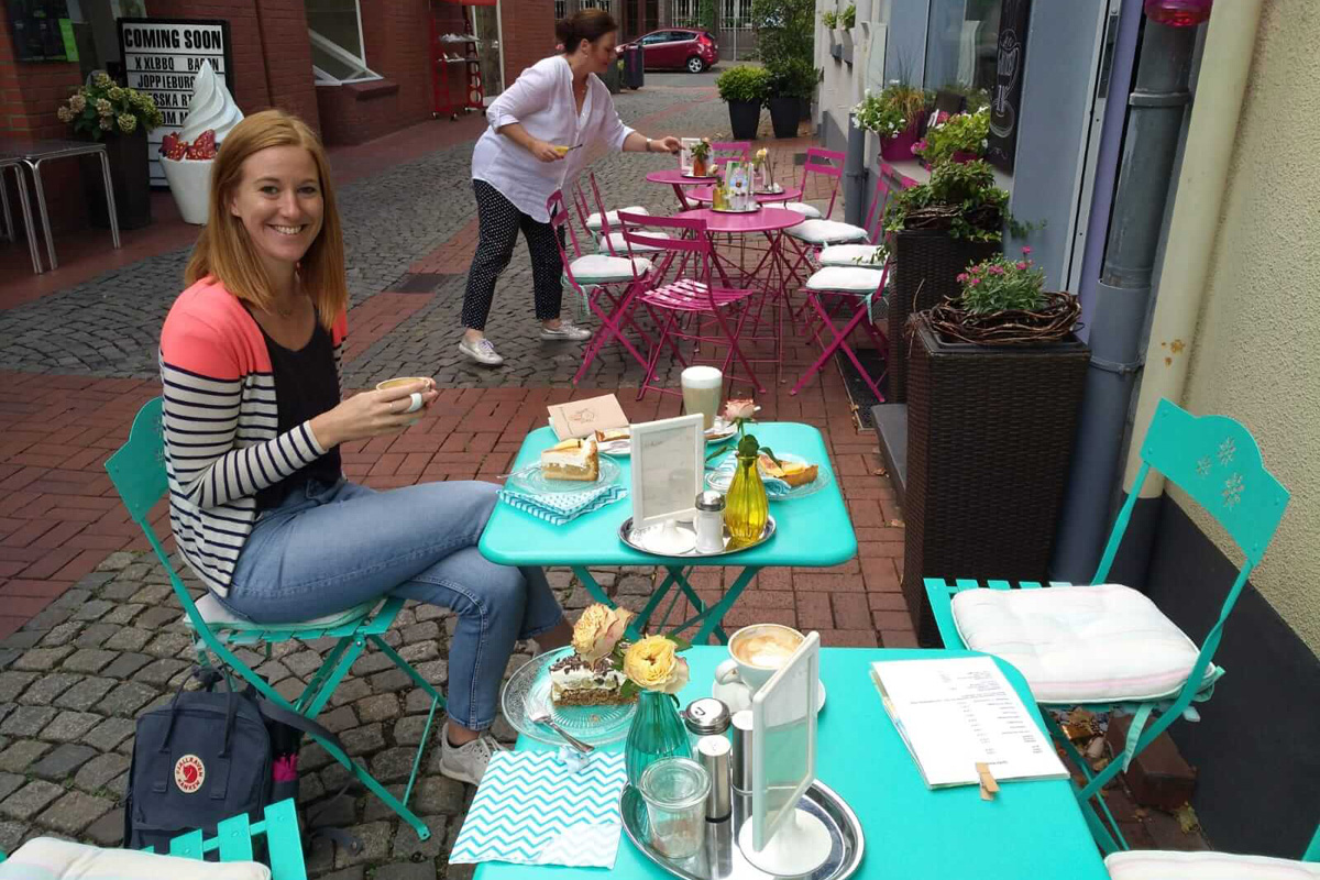 Das Bild zeigt Sarah vor dem Café heimelie.