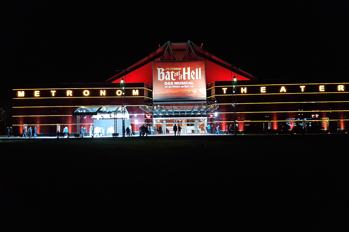 Ganz in rot leuchtet das Metronom Theater in Oberhausen bei Nacht