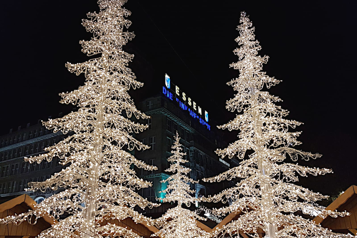 Das Bild zeigt zwei Lichter-Weihnachtsbäume auf dem Weihnachtsmarkt in Essen.