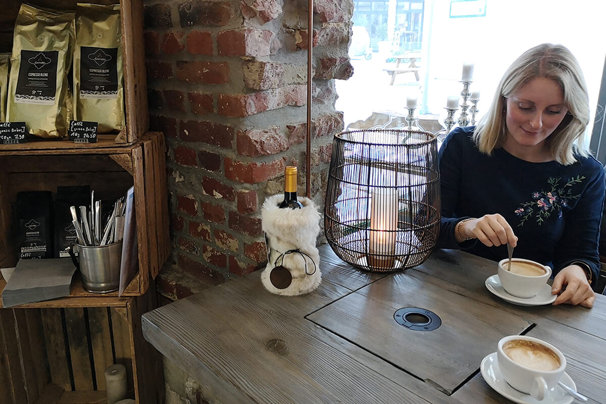 Das Bild zeigt Katalina mit einem Cappuccino im Coretto in Bottrop