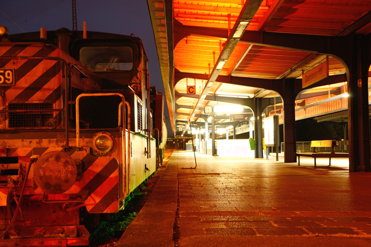 Das Bild zeigt eine Lok bei Nacht auf einem Bahnsteig