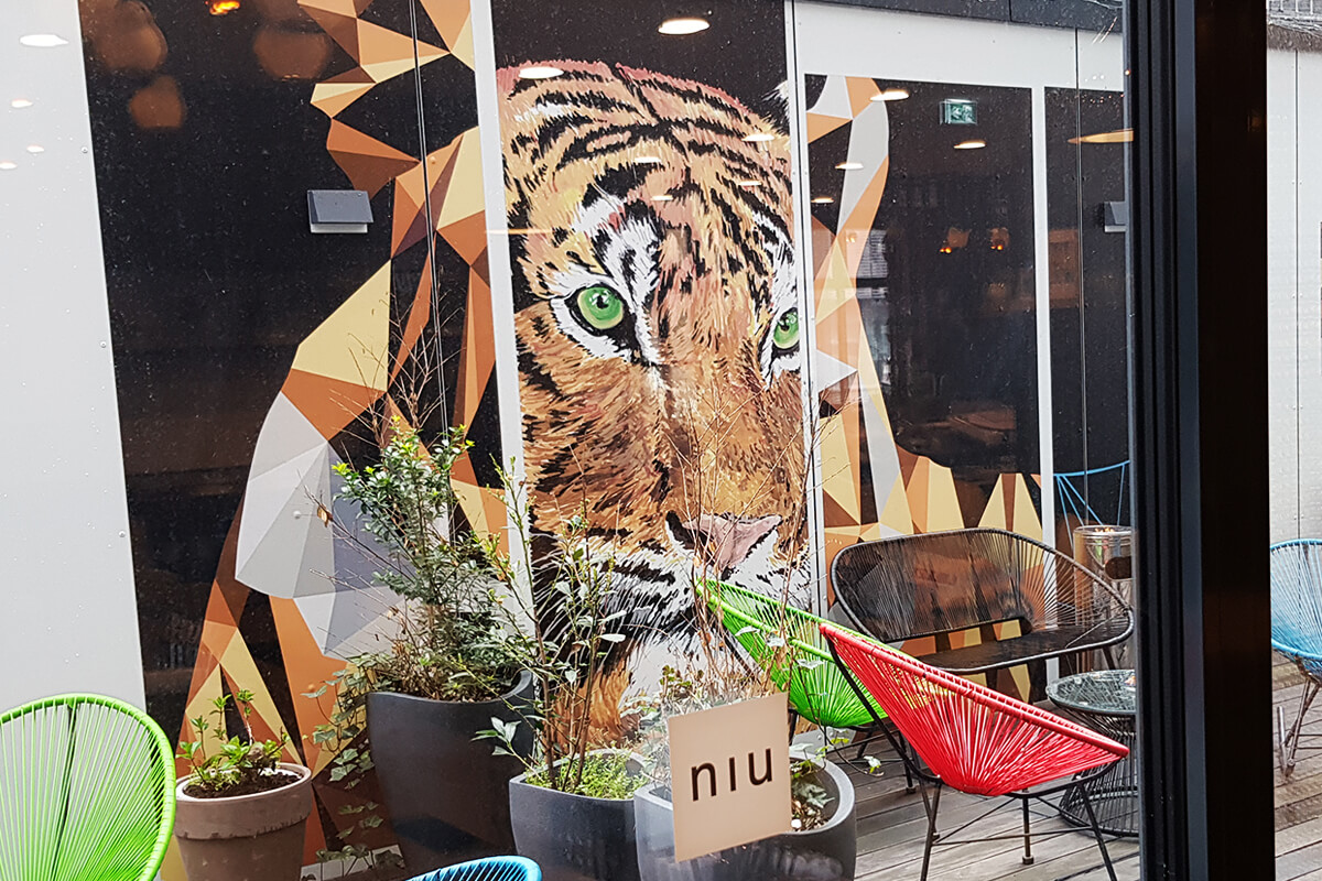 Das Foto zeigt eine tierische Wandmalerei in Form eines Tiger im Hinterhof des niu Cobbles in Essen