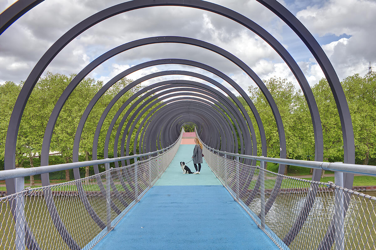 Das Foto zeigt Bloggerin Rebecca mit Hund Fino auf der Brücke Slinky Springs to Fame im Kaisergarten Oberhausen