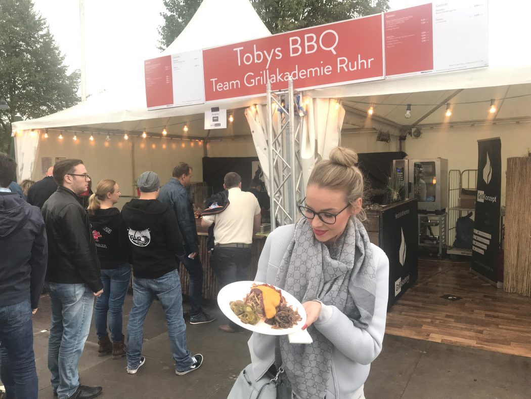 Das Bild zeigt Sandra vor einem Essenstand auf dem Zeltfestival Ruhr