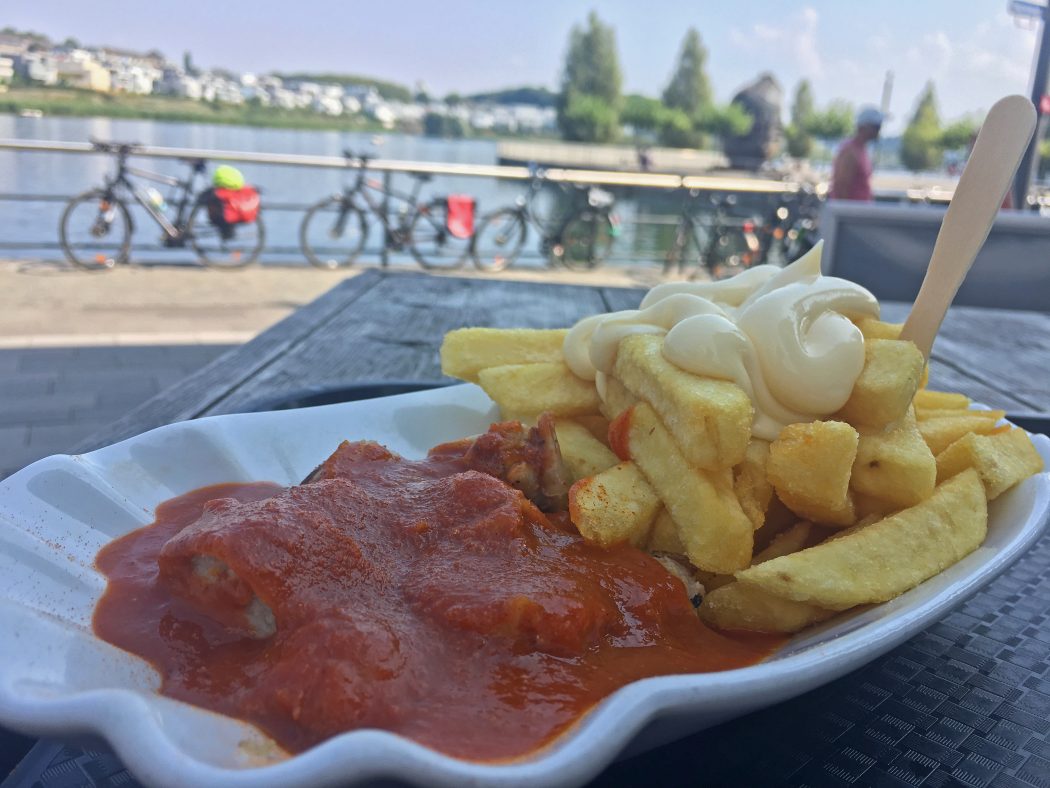 Das Bild zeigt eine Portion Currywurst und Pommes