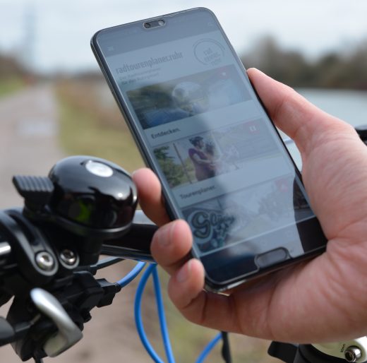 Das Foto zeigt ein Handy, auf dem der digitale radtourenplaner.ruhr angezeigt wird