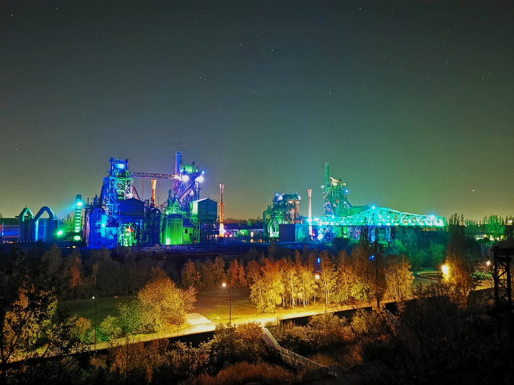 Das Foto zeigt den Sternenhimmel über dem beleuchteten Landschaftspark Duisburg-Nord