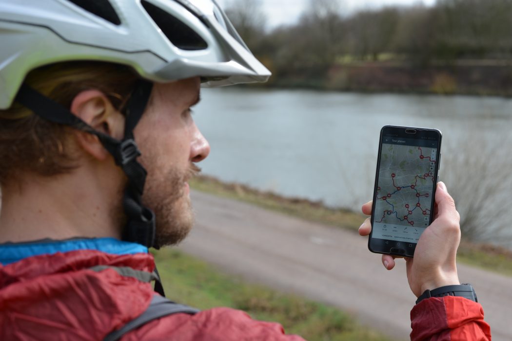 Das Foto zeigt einen Radfahrer mit dem radtourenplaner.ruhr auf seinem Handy