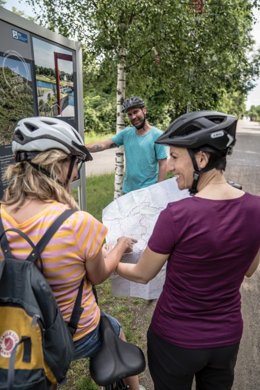 Das Foto zeigt Radfahrer im Ruhrgebiet mit einer Radkarte des radrevier.ruhr