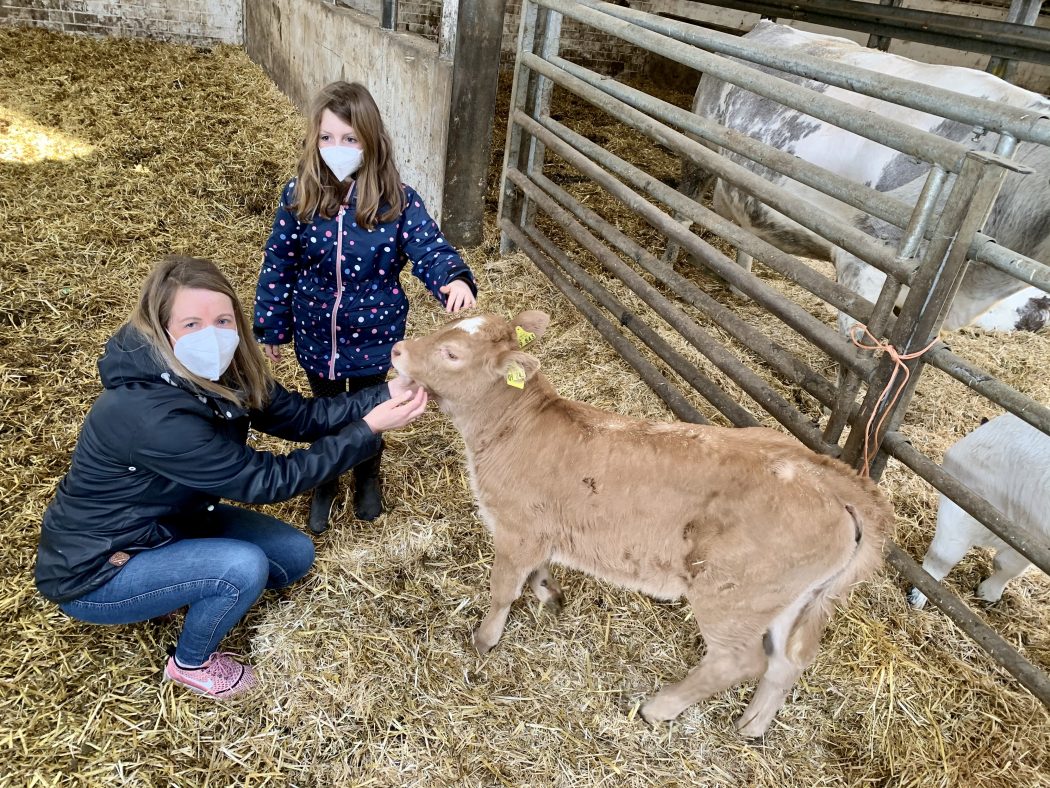 Das Foto zeigt Nina und ihre Tochter mit einem Kälbchen auf dem Bauernhof Sagel in Bottrop-Kirchhellen