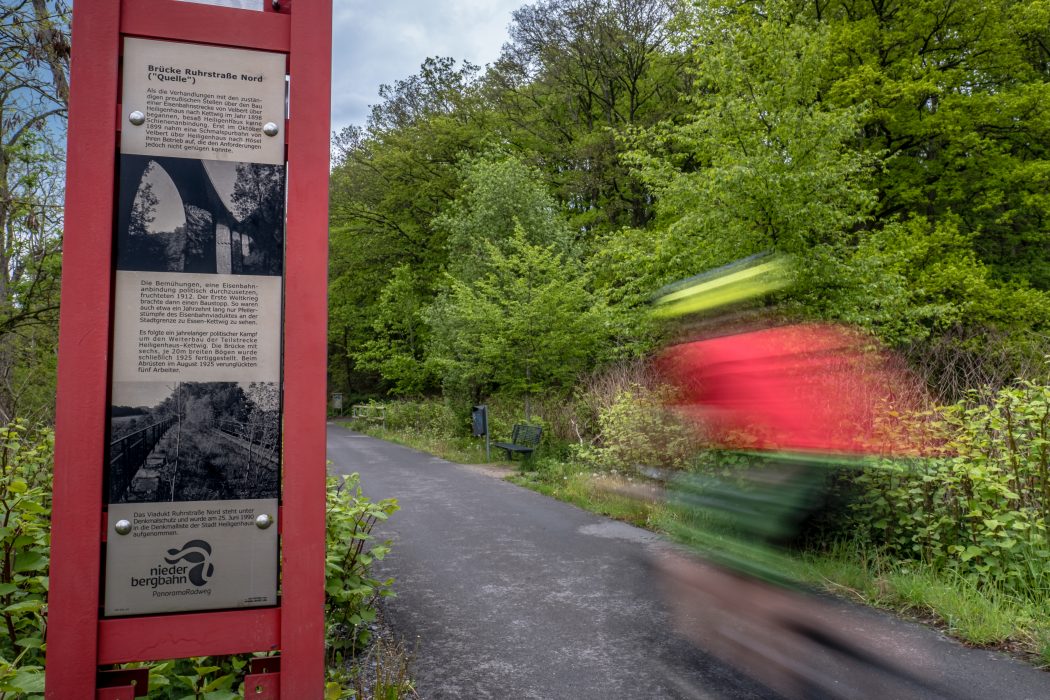 Das Foto zeigt eine Infotafel am Wegesrand der Niederbergbahntrasse in Essen-Kettwig