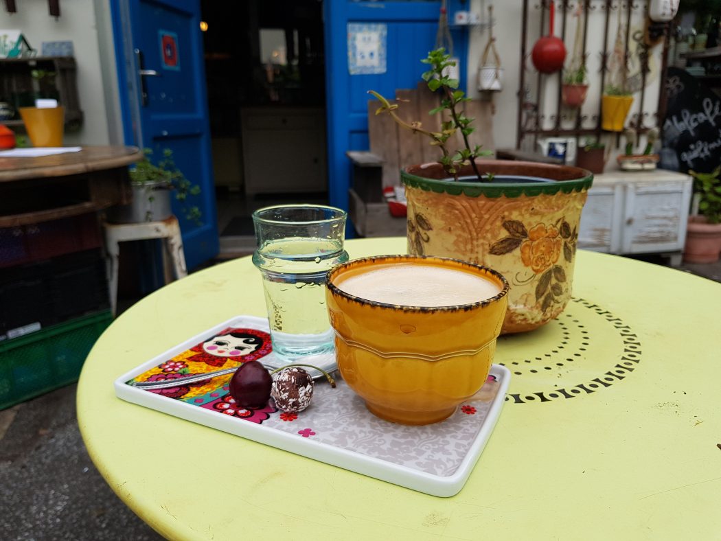 Das Foto zeigt einen Cappuccino und Wasser im Hof des Hofcafés in Dortmund