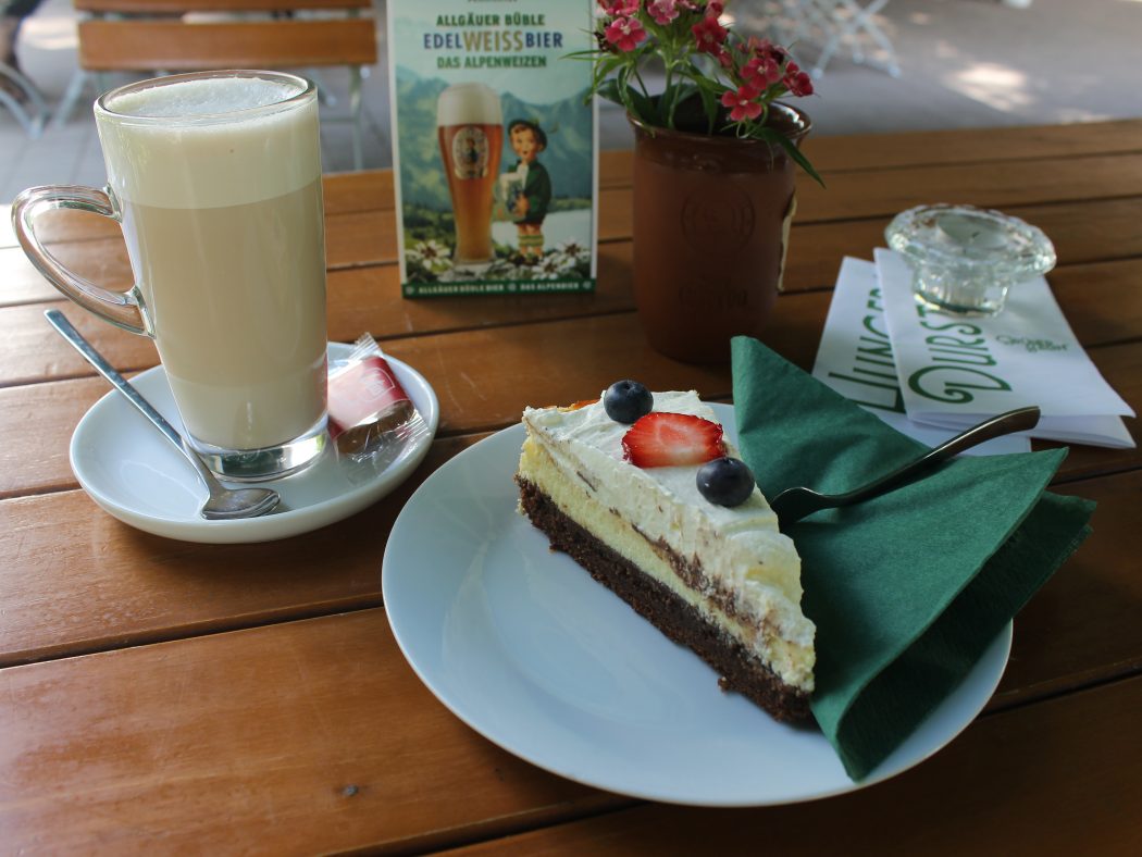 Das Foto zeigt Brownie-Cheesecake und Chai-Latte im Biergarten des Grünen Salons in der Nordstadt von Dortmund