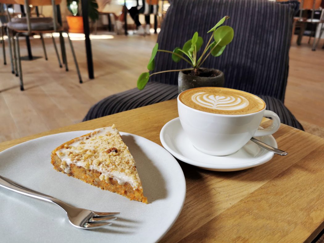 Das Foto zeigt Karotte-Walnuss-Kuchen und Cappuccino im STÜH33 in Bochum