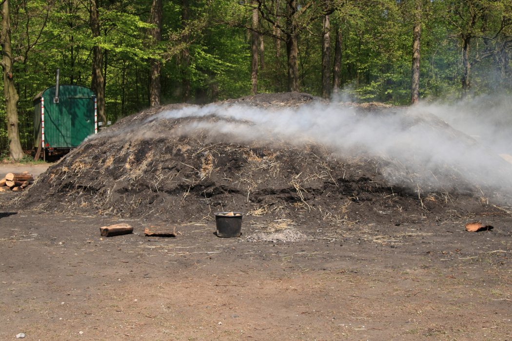 Das Foto zeigt einen Holzkohlenmeiler bei Flaesheim