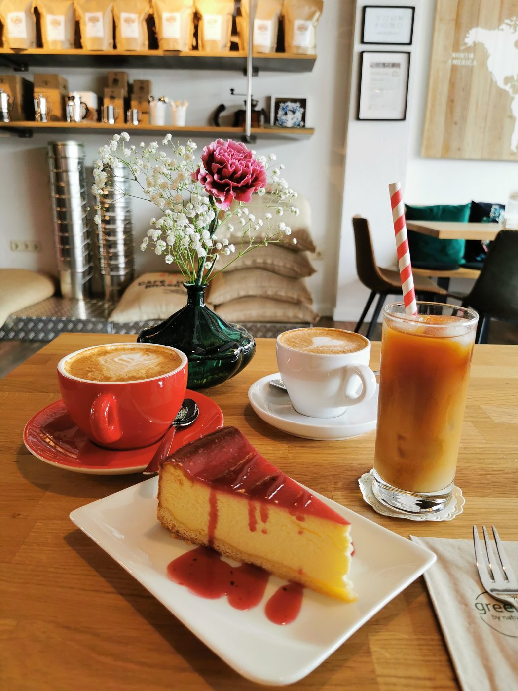 Das Foto zeigt Käsekuchen, Cappuccino und Cold Brew der Kaffeerösterei RöstCult in Duisburg