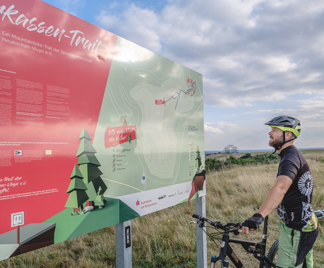 Das Foto zeigt Jochen an der Infotafel des Sparkassen-Trails auf der Halde Norddeutschland in Neukirchen-Vluyn