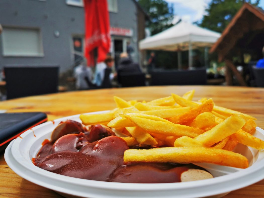 Das Foto zeigt Currywurst Pommes am Imbiss am Tetraeder in Bottrop