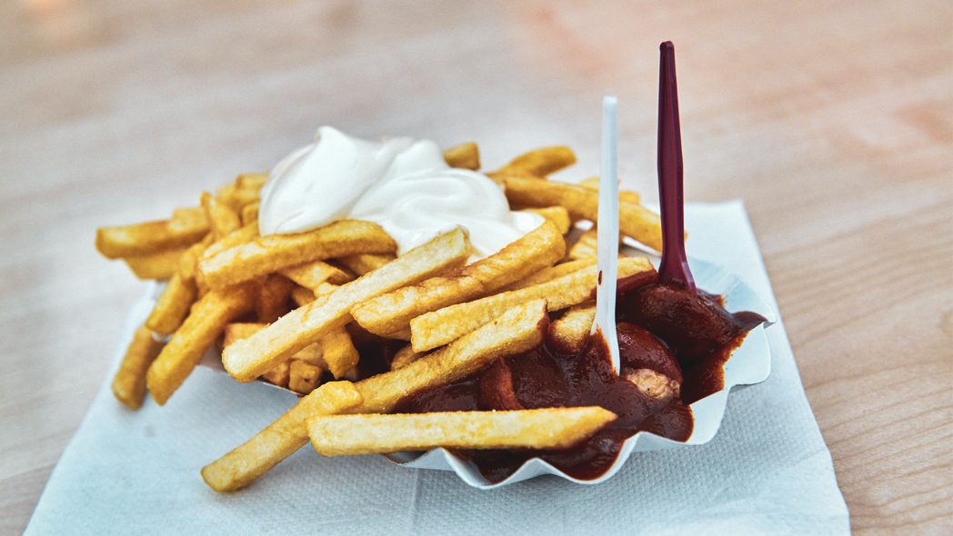 Das Bild zeigt Currywurst und Pommes