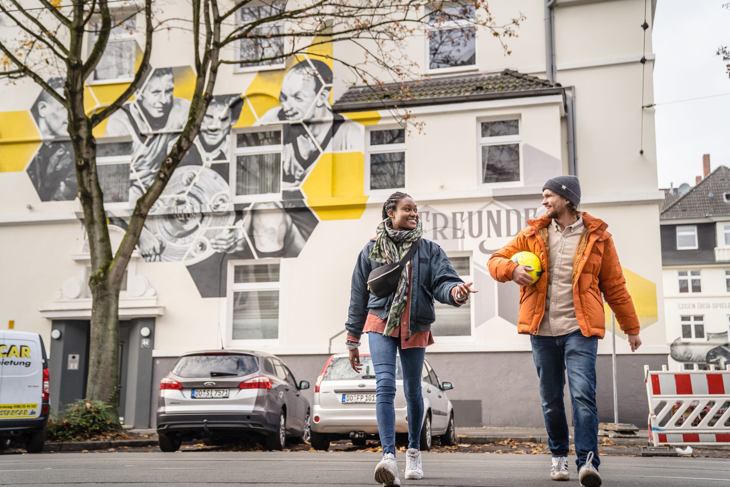 Zwei Personen vor einem Fußball Mural in Dortmund