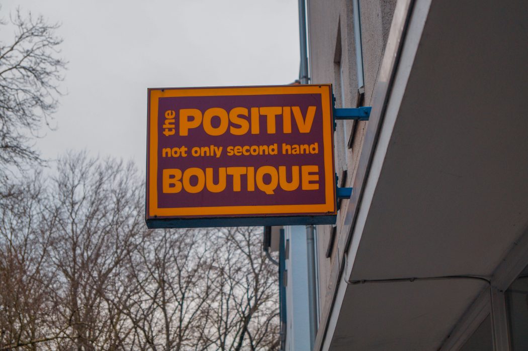 Das Foto zeigt das Schild am Eingang des Second Hand Ladens The Positiv Botique in Essen