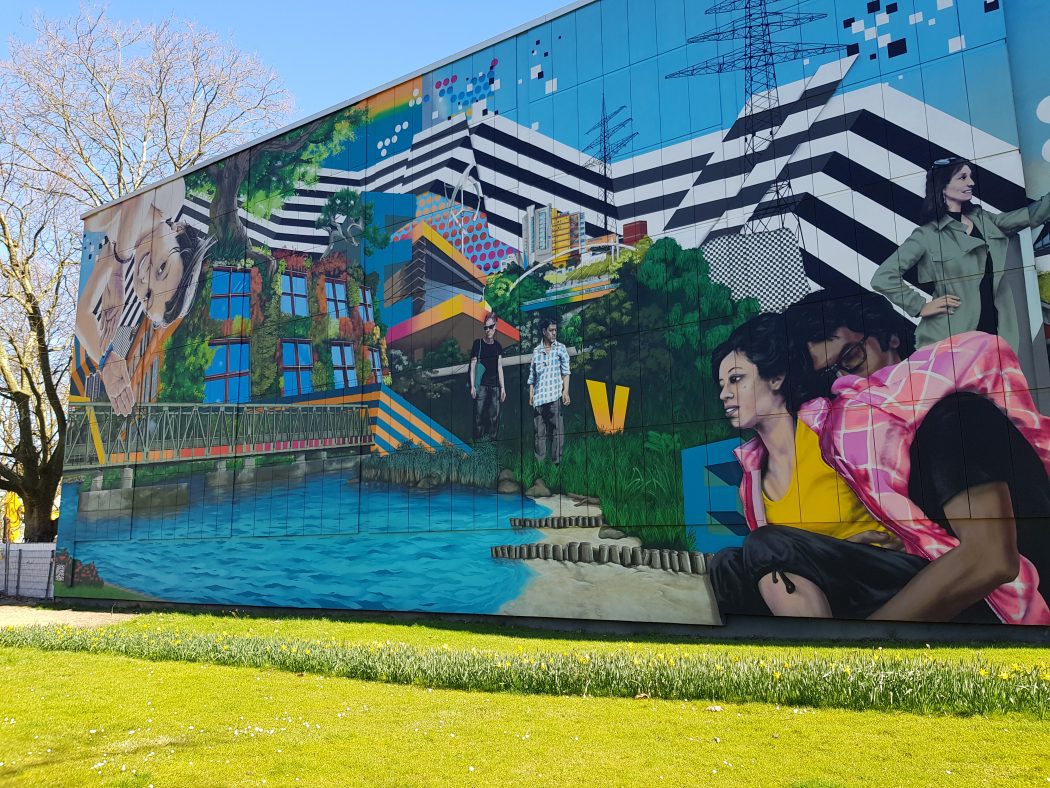 Das Foto zeigt ein riesiges Mural auf einer Gebäudefassade in Essen