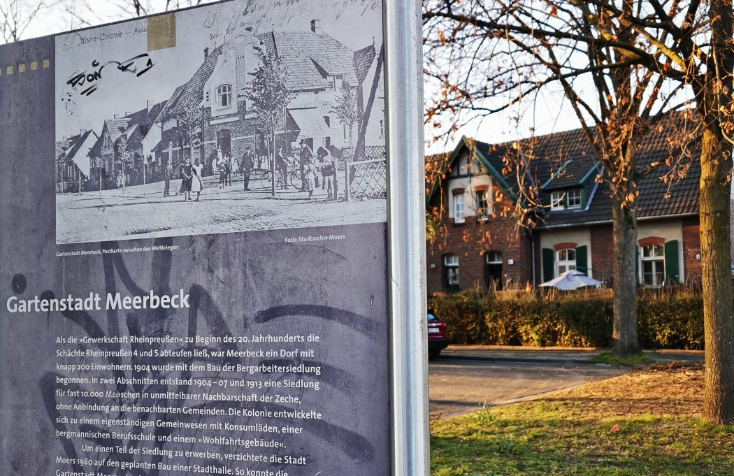 Das Foto zeigt eine Infotafel am Eingang der Gartenstadt Meerbeck in Moers