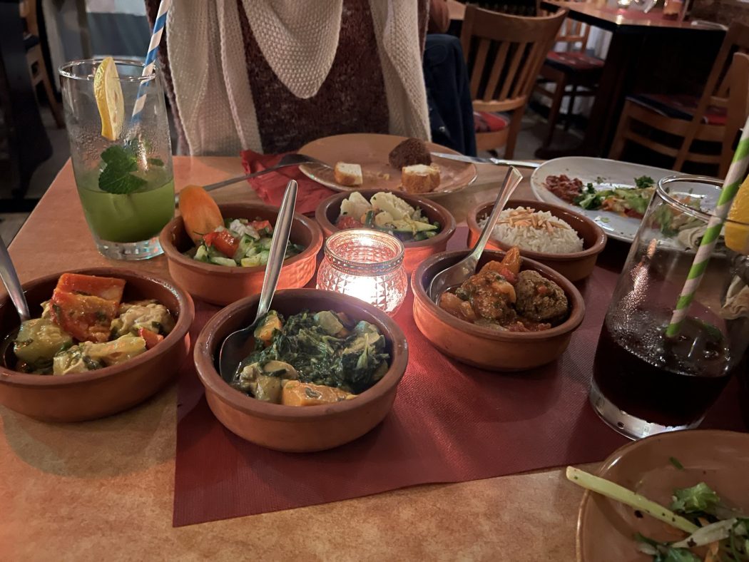 Das Foto zeigt Hähnchen mit Gemüse, Hackbällchen in Tomatensauce und vegetarisches Spinat-Kokoscurry im Restaurant Karawane in Essen