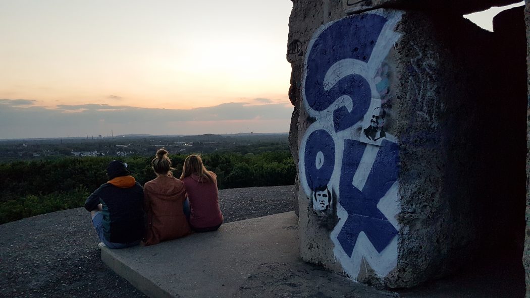 Das Foto zeigt drei Menschen auf der Halde Rheinelbe im Kreativquartier Ückendorf in Gelsenkirchen