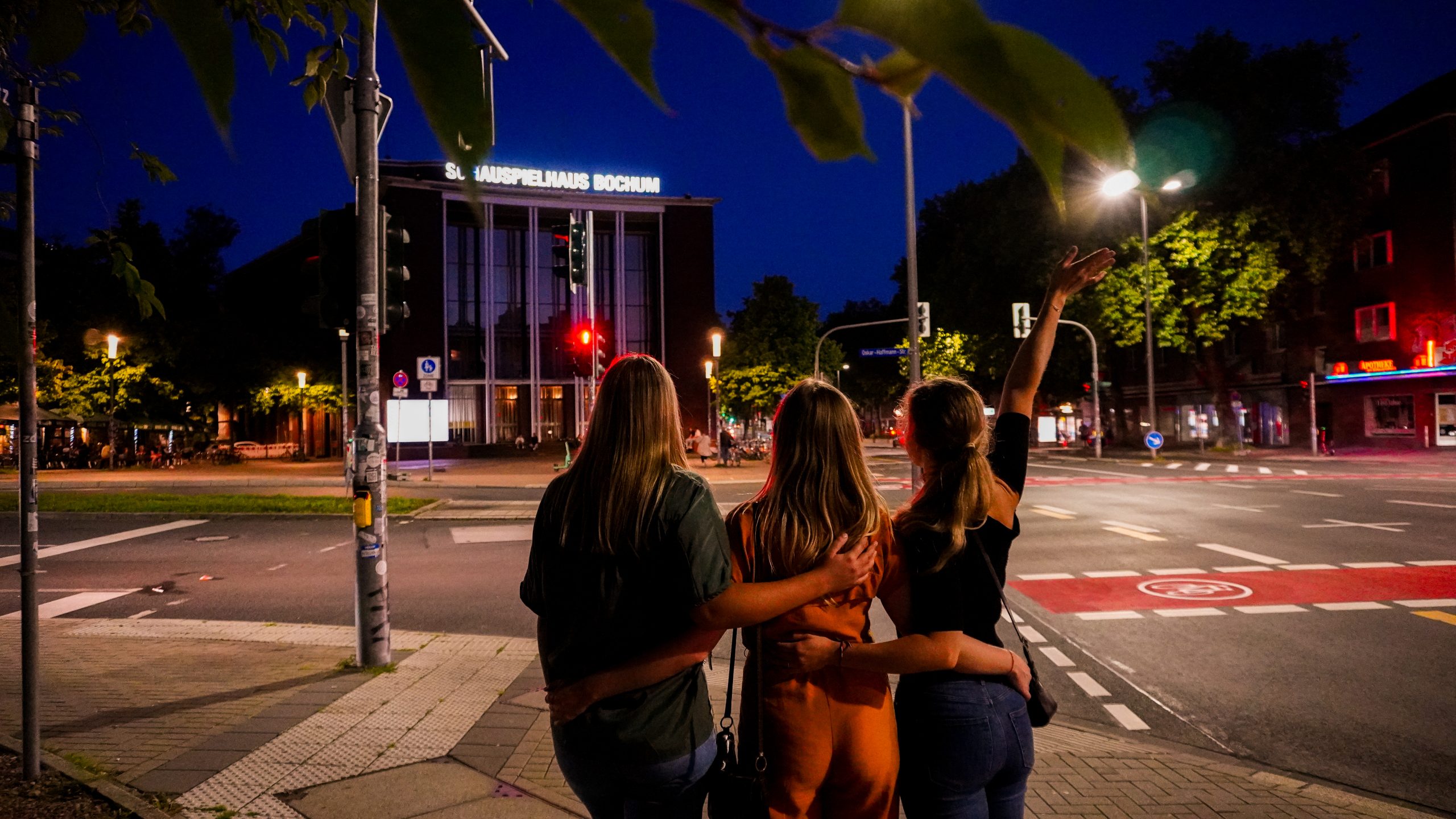 Das Foto zeigt Eileen, Leonie und Christin nachts am Schauspielhaus Bochum