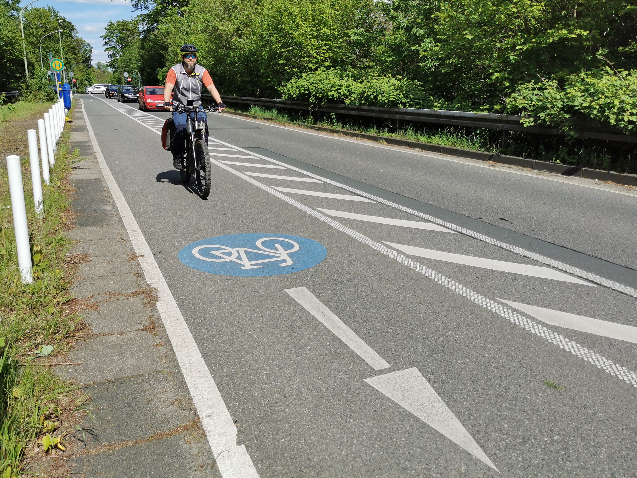 Das Foto zeigt Jochen auf der Radtour auf einem Radweg, der entlang der Straße führt