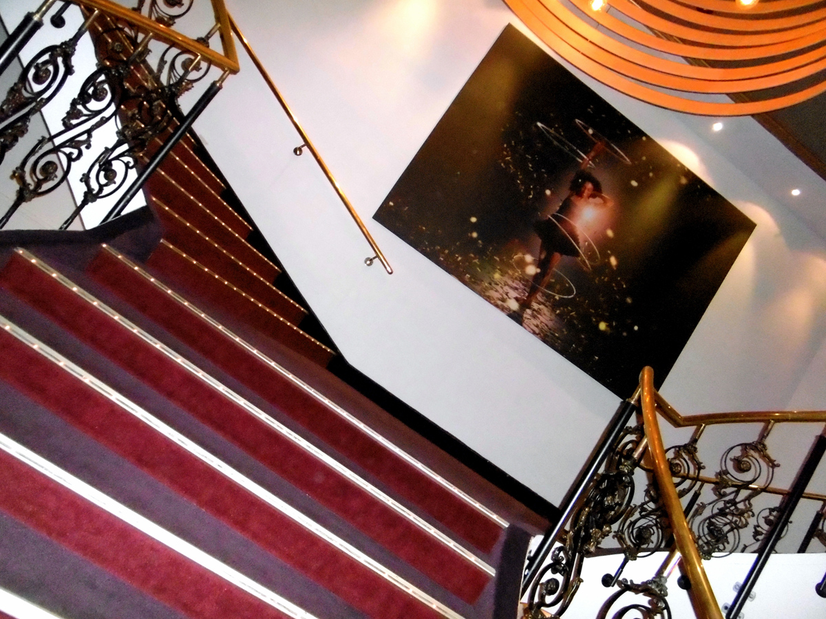 Das Foto zeigt die verschnörkelte Treppe mit vergoldetem Geländer im GOP Varieté-Theater Essen.
