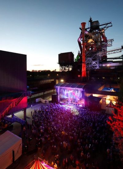 Das Bild zeigt ein Konzert vor den Hochöfen bei der Traumzeit im Landschaftspark Duisburg-Nord.