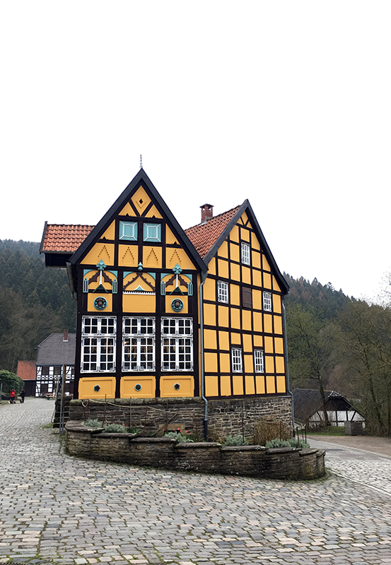 Das Bild zeigt ein gelbes Fachwerkhaus im LWL Freilichtmuseum Hagen