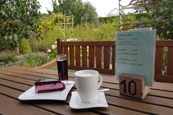 Das Foto zeigt Kaffee und Kuchen im idyllischen Garten des Hof Emscher-Mündung