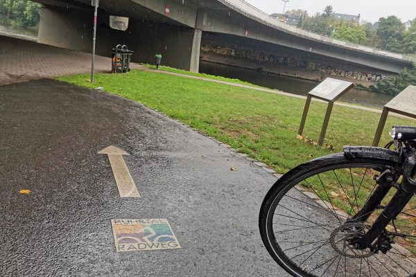 Das Foto zeigt eine Bodenmarkierung mit RuhrtalRadweg Logo in Essen-Werden