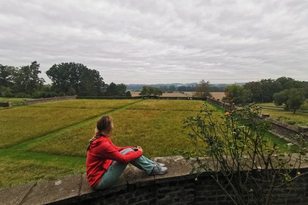 Das Foto zeigt Sandra mit Blick von der Mauer der Gutsbrennerei Bimberg auf den RuhrtalRadweg in Iserlohn