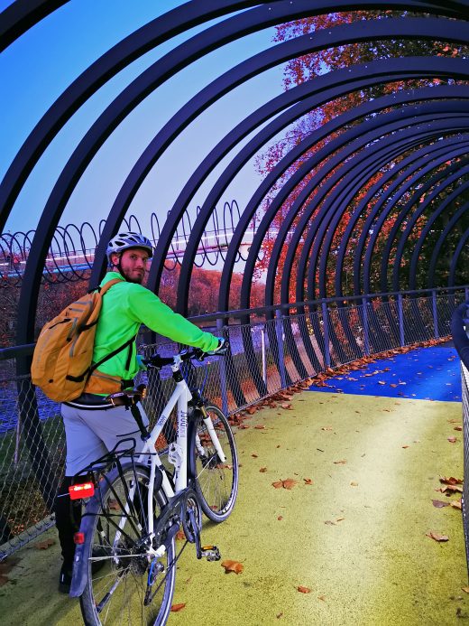 Das Foto zeigt einen Radfahrer auf der beleuchteten Brücke Slinky Springs to Fame in Oberhausen