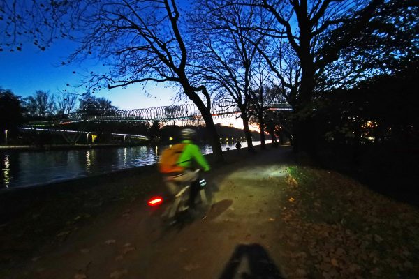 Das Foto zeigt einen Radfahrer im Dunkeln am Rhein-Herne-Kanal in Oberhausen