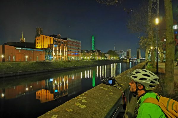 Das Foto zeigt einen Radfahrer beim Fotografieren im dunklen Innenhafen Duisburg