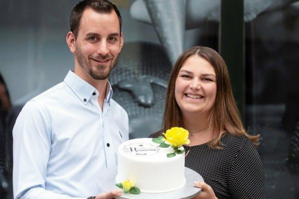 Das Foto zeigt die Inhaber der Confiserie Harmonie mit einer kleinen Torte