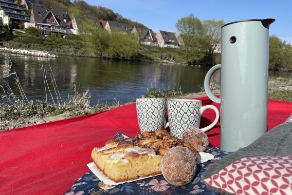 Das Foto zeigt Kaffee und Kuchen am Ruhrufer in Hattingen - ein perfekter Ort für ein Picknick im Ruhrgebiet