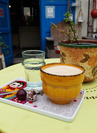 Das Foto zeigt einen Cappuccino und Wasser im Hof des Hofcafés in Dortmund