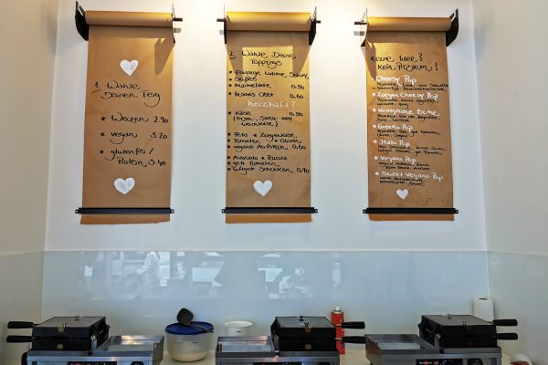 Das Foto zeigt Waffeleisen und Bestellplakate im herzallerliebst in Dortmund