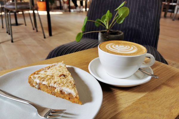 Das Foto zeigt Karotte-Walnuss-Kuchen und Cappuccino im STÜH33 in Bochum