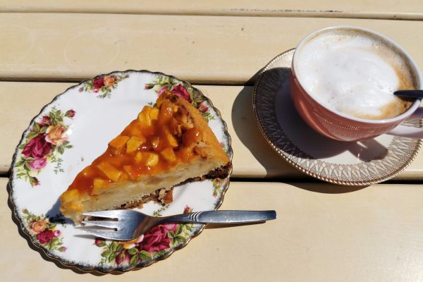 Das Foto zeigt Apfelkuchen und Cappuccino auf der Sonnenterrasse des "Unser Lieblingscafé" in Xanten